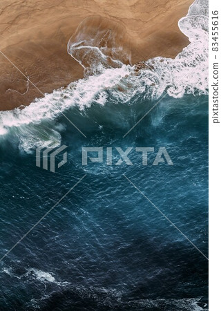 Beautiful sea background for your smartphone. Beautiful sandy beach with blue ocean, vertical view. Seascape from a quadrocopter. Beautiful seascape background. Sandy beach on the island. Copy space 83455616