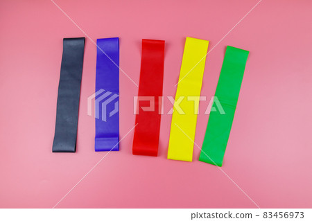 Set of elastic rubber bands for fitness on a pink background. Top view 83456973