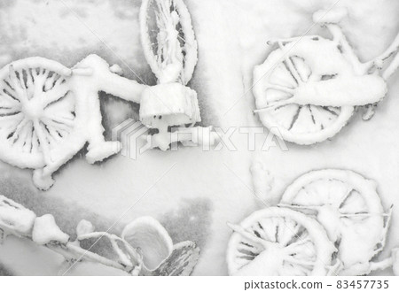 許多倒下的自行車，它們的輪廓在冬日的白雪中浮現 83457735