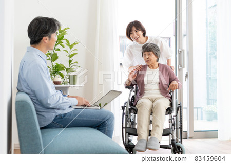 一個男人和一個坐輪椅的奶奶和一個推著輪椅的女孩說話 83459604