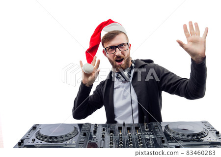 Funny emotional dj in Santa's hat, glasses plays music on a turntable raises hands up. studio shot  Funny emotional dj in Santa's hat, glasses plays music on a turntable raises hands up. studio shot  83460283