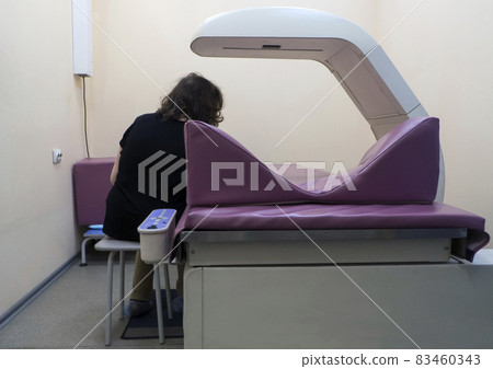 A woman undergoes a study - bone densitometry of the hands. Detects a decrease in bone density in the early stages. Osteoporosis Test A woman undergoes a study - bone densitometry of the hands. Detects a decrease in bone density in the early stages. Osteoporosis Test 83460343