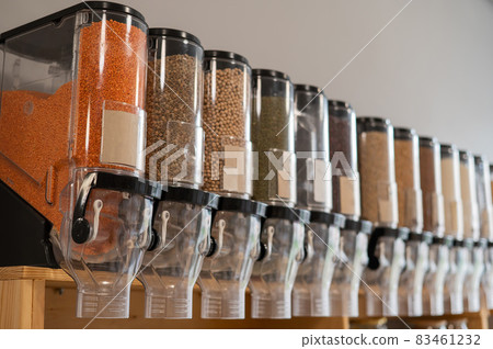 A woman fills a jar with red lentils. Selling bulk goods by weight in an eco store. Trade concept without plastic packaging 83461232