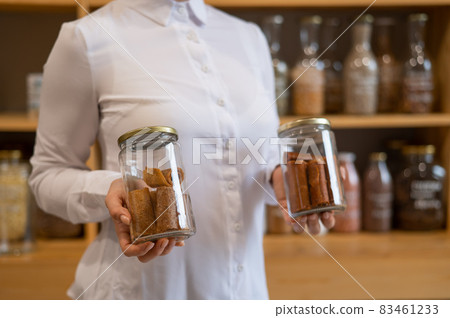 A woman holds a jar with Sweet pureed fruit pastila. Natural weight sweets in an eco store 83461233