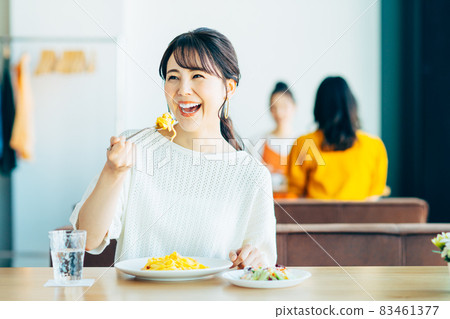 A young woman eating pasta at a restaurant A young woman eating pasta at a restaurant 83461377