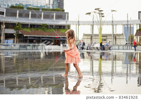 happy baby girl play with water in a fountain happy baby girl play with water in a fountain 83461928