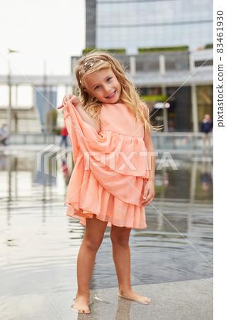 happy baby girl play with water in a fountain happy baby girl play with water in a fountain 83461930