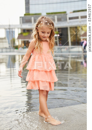 happy baby girl play with water in a fountain happy baby girl play with water in a fountain 83461937