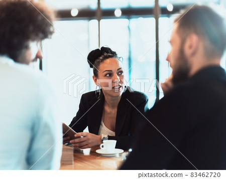 A group of business people on a coffee break use laptops, tablets and smartphones while discussing new business projects. A group of business people on a coffee break use laptops, tablets and smartphones while discussing new business projects. 83462720