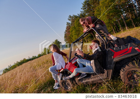 group young happy people enjoying beautiful sunny day while driving a off road buggy car 83463018