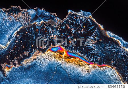 Extreme macro photograph of Vitamin C crystals forming abstract modern art patterns, when illuminated with polarized light, under a microscope objective with 10x magnification Extreme macro photograph of Vitamin C crystals forming abstract modern art patterns, when illuminated with polarized light, under a microscope objective with 10x magnification 83463150