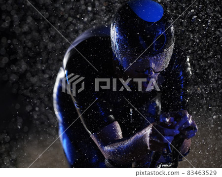 triathlon athlete riding bike fast on rainy night 83463529