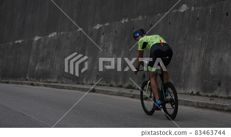 triathlon athlete riding a bike on morning training 83463744