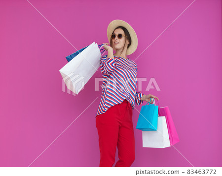 Young woman with shopping bags on pink background Young woman with shopping bags on pink background 83463772
