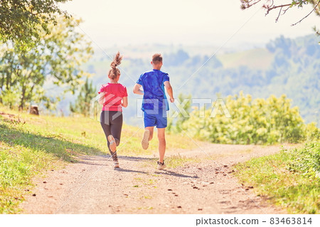 couple enjoying in a healthy lifestyle while jogging on a country road couple enjoying in a healthy lifestyle while jogging on a country road 83463814