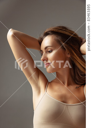 Close-up portrait of young beautiful slim woman without makeup isolated over gray studio background. Natural beauty concept. Close-up portrait of young beautiful slim woman without makeup isolated over gray studio background. Natural beauty concept. 83463895