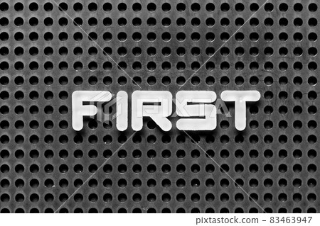 White alphabet letter in word first on black pegboard background White alphabet letter in word first on black pegboard background 83463947