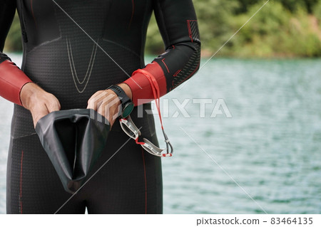 triathlon athlete getting ready for swimming training on lake triathlon athlete getting ready for swimming training on lake 83464135