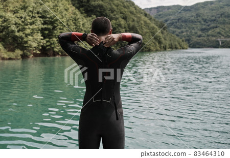 triathlon athlete getting ready for swimming training on lake 83464310