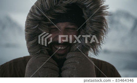 man at winter in stormy weather wearing warm fur jacket man at winter in stormy weather wearing warm fur jacket 83464346