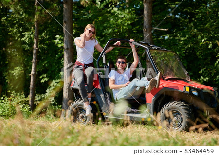 couple enjoying beautiful sunny day while driving a off road buggy couple enjoying beautiful sunny day while driving a off road buggy 83464459
