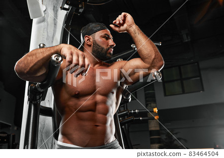 bald brutal sexy strong bodybuilder athletic fitness man pumping up abs muscles workout bodybuilding concept background 83464504