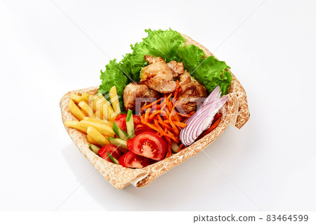 chicken kebab on thin pita bread with sauce with French fries and salad on white background. Fast food 83464599