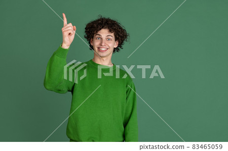 Cropped portrait of young man in green sweater with excited facial expression isolated over dark green background. Ideas Cropped portrait of young man in green sweater with excited facial expression isolated over dark green background. Ideas 83465059