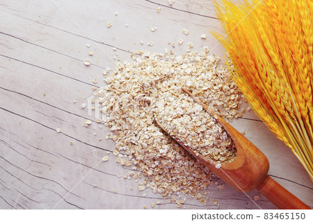 Close up of oats flakes on spoon on table  83465150