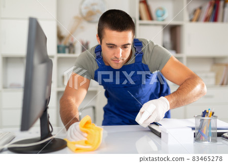 Cleaning worker wiping office desk with detergent 83465278