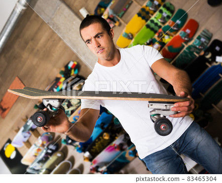 Man choosing skateboard in store 83465304