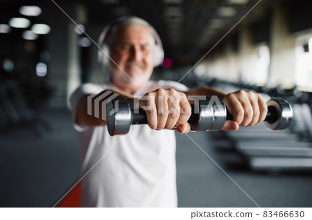 Old man in headphones, exercise with dumbbells Old man in headphones, exercise with dumbbells 83466630