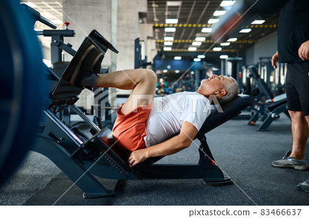 Elderly man on exercise machine in gym Elderly man on exercise machine in gym 83466637
