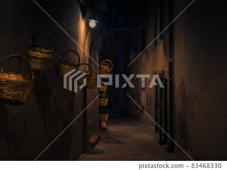 Evening street with bright lanterns baskets on wall, Tropea, Italy 83468330