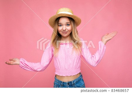 Photo shot of young beautiful cute happy blonde woman wearing stylish pink crop top and straw hat 83468657