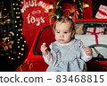 baby sitting on red Christmas car 83468815