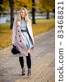 Woman in autumn park 83468821