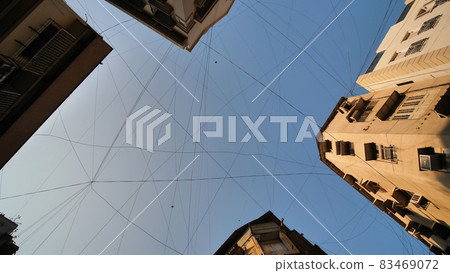 Electric wires hanging on the buildings in Mumbai. 83469072
