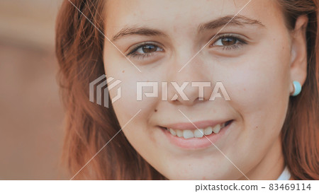 Portrait of a 16 year old red-haired smiling girl. 83469114