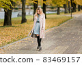 Woman in autumn park 83469157