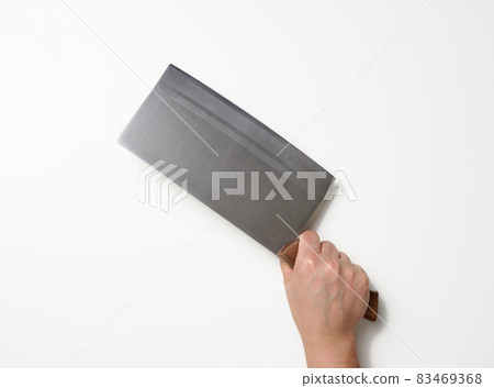 female hand holding a large sharp kitchen knife for cutting meat on a white background female hand holding a large sharp kitchen knife for cutting meat on a white background 83469368