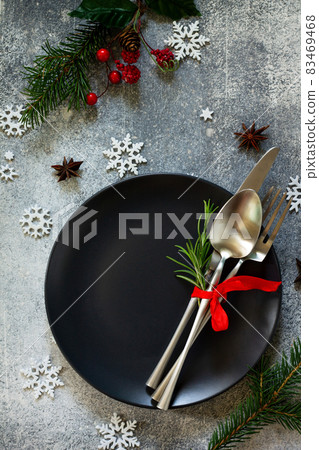 Christmas background. Christmas decoration table. Festive black plate and cutlery with Christmas decor on retro festive table. Top view flat lay. Christmas background. Christmas decoration table. Festive black plate and cutlery with Christmas decor on retro festive table. Top view flat lay. 83469468