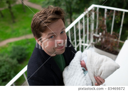Young father and newborn baby girl spending time together on balcony for first time. Young father and newborn baby girl spending time together on balcony for first time. 83469872