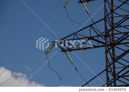 Power lines on background of blue sky close-up. Electric hub on pole. Electricity equipment with copy space. Wires of high voltage in sky 83469978