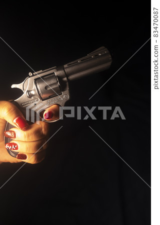 Woman holding pistol gun 83470087