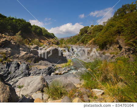 Gole Alcantara Sicilian national park. Alcantara river gorge canyon with volcanic lava caves and rocks. A touristic attraction in Sicily Italy Gole Alcantara Sicilian national park. Alcantara river gorge canyon with volcanic lava caves and rocks. A touristic attraction in Sicily Italy 83470104