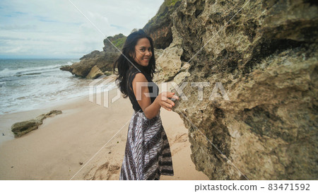 Indonesian girl posing on a beautiful and rocky beach in Bali. Idonezia. 83471592