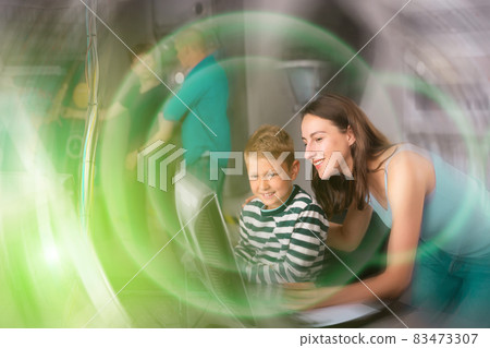 Young mother and preteen son using computer in quest room Young mother and preteen son using computer in quest room 83473307