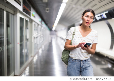 Woman using smartphone in subway station Woman using smartphone in subway station 83473308