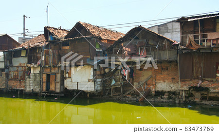 Slum area on the riverbank in Jakarta. Indonesia. 83473769